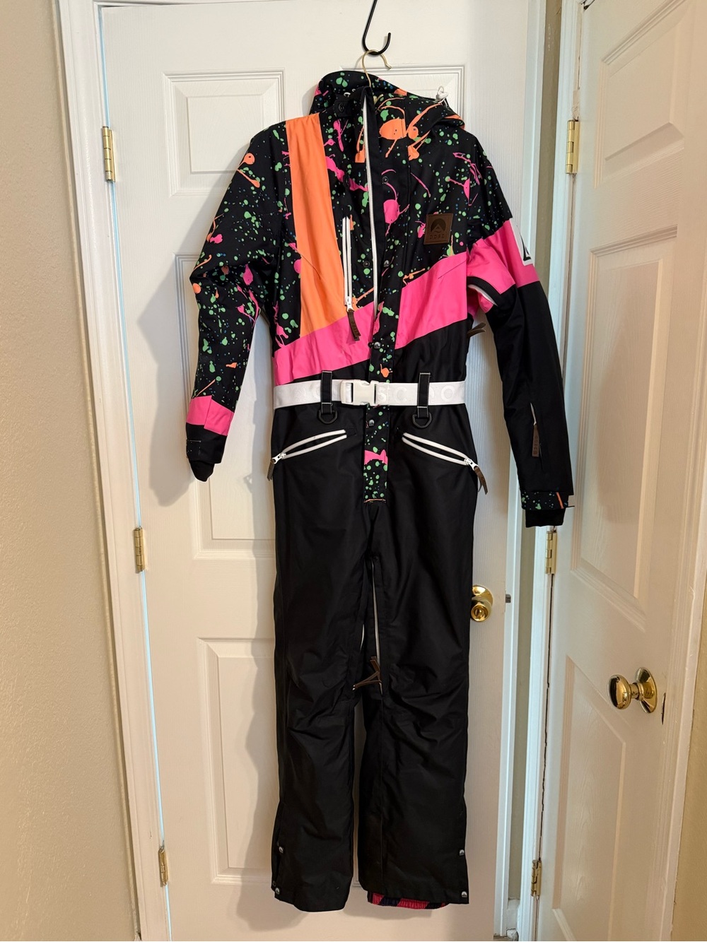 OOSC Clueless ski suit featuring a bold 90s-inspired neon paint-splatter pattern